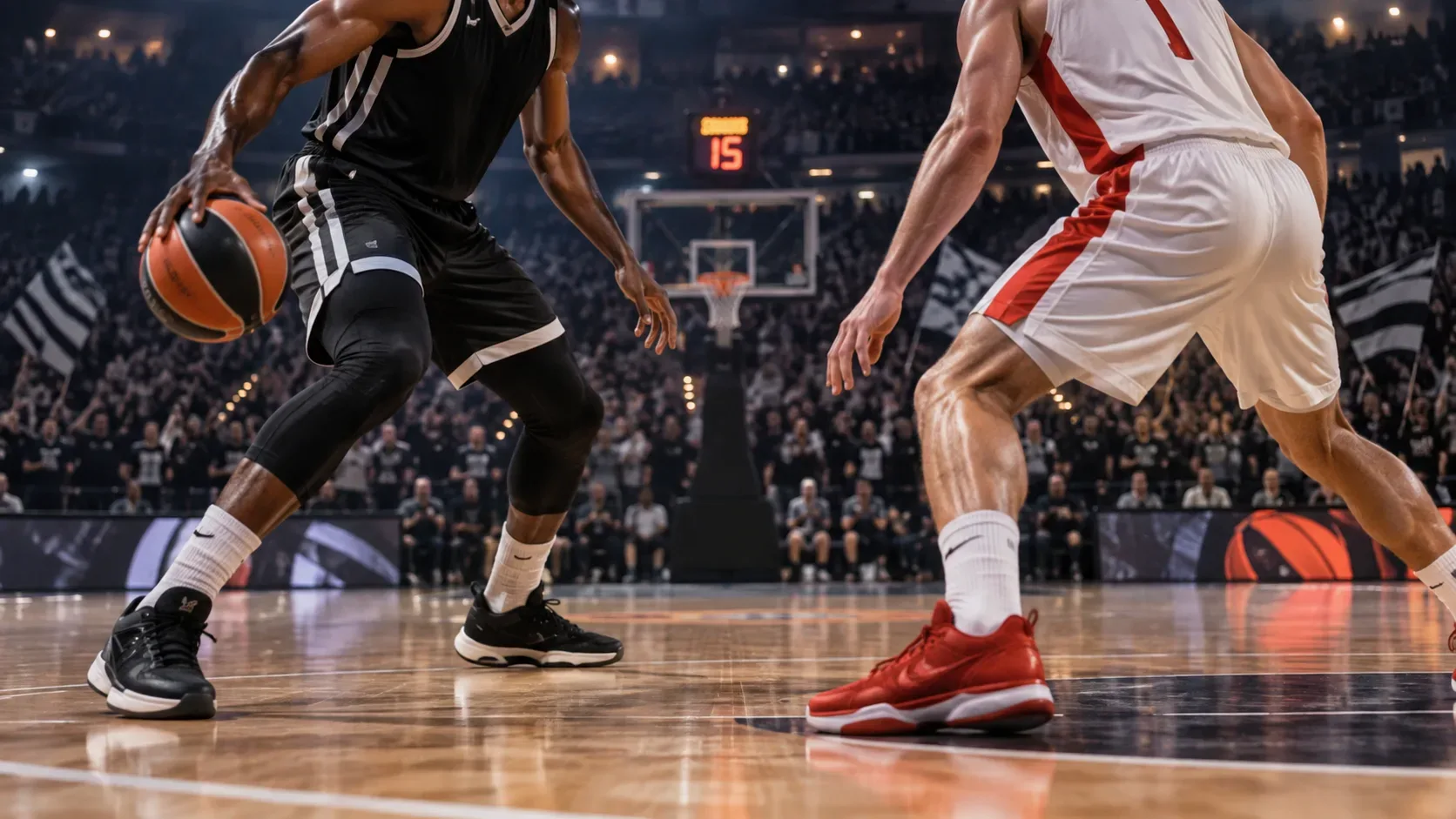 Dois jogadores de basquete disputam a bola em uma arena coberta lotada, com uniformes em tons de preto e de branco com vermelho.